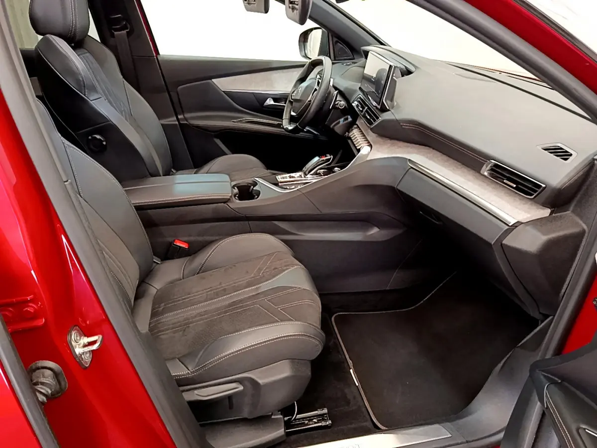 Intérieur côté conducteur du Peugeot 3008 GT rouge 2021, avec sièges cuir et tableau de bord moderne tactile.