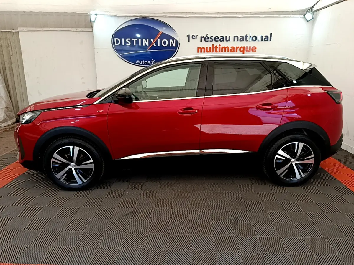 Profil côté gauche du Peugeot 3008 GT rouge de 2021 avec toit noir et jantes alliage bicolores.