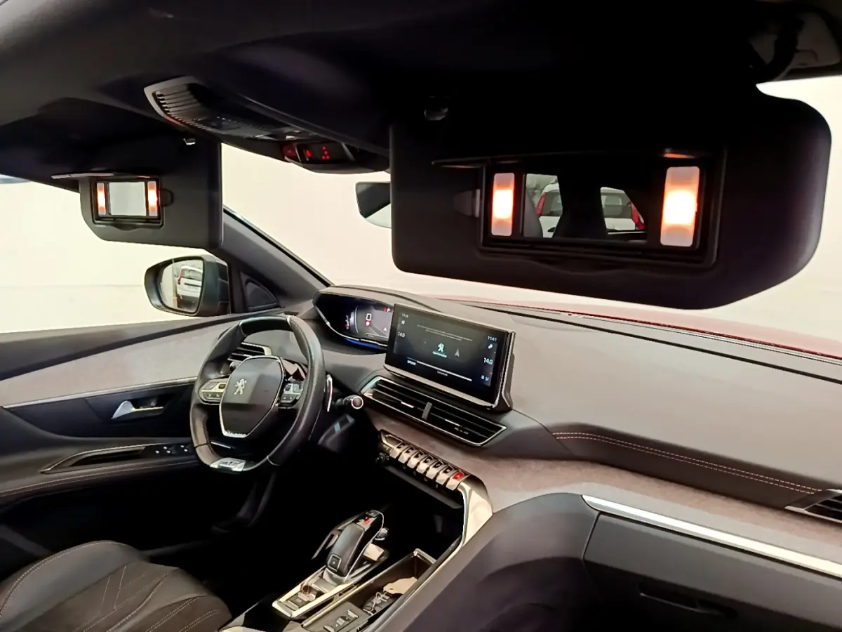 Intérieur du Peugeot 3008 GT 2021 vu côté conducteur, volant cuir et écran tactile central allumé.