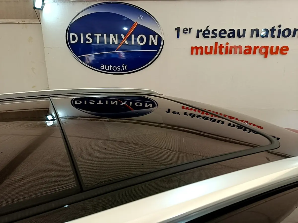 Toit ouvrant panoramique en verre du Peugeot 3008 GT rouge, vue rapprochée sur le toit et les barres de toit chromées.