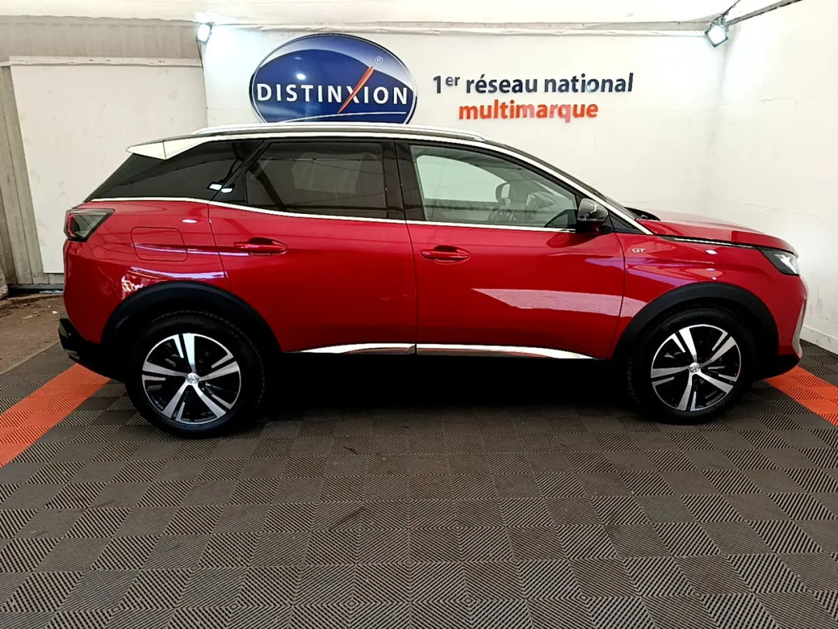 Profil côté gauche du Peugeot 3008 GT rouge 2021 avec toit blanc et jantes alliage noires et argentées.