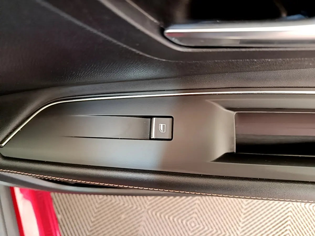Détail de la commande de lève-vitre sur la portière côté gauche d’un Peugeot 3008 GT rouge 2021.