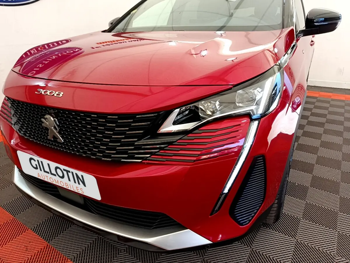 Vue 3/4 avant droit d'un Peugeot 3008 rouge avec calandre noire et feux LED distinctifs en forme de griffes.