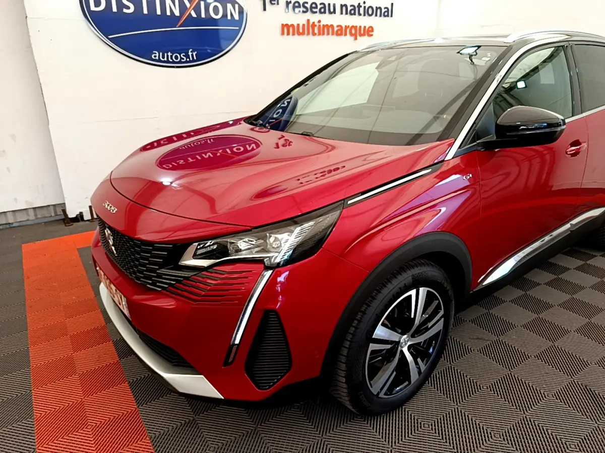 Peugeot 3008 rouge vue 3/4 avant droit, avec phares LED et jantes alliage distinctives dans un showroom.