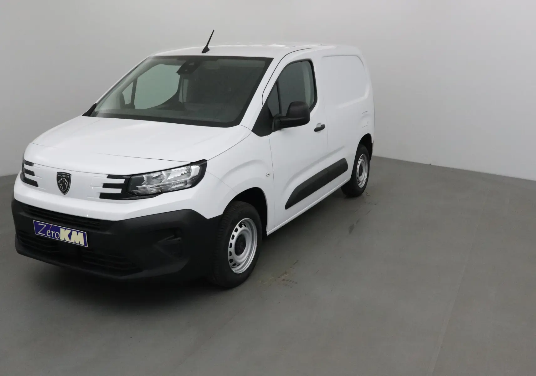 Vue 3/4 avant d'un utilitaire Peugeot Partner blanc avec calandre noire et jantes acier simples.