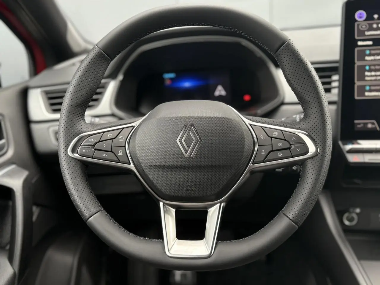 Vue rapprochée du volant en cuir perforé noir avec commandes intégrées du Renault Captur 2026, intérieur moderne.