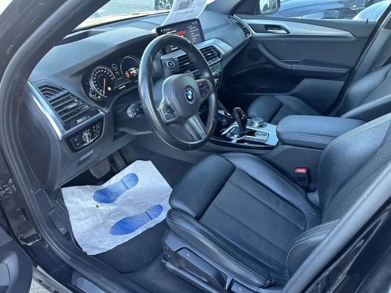 Intérieur noir de BMW X4 X-Line 2019, vue côté conducteur montrant volant, tableau de bord et sièges cuir.