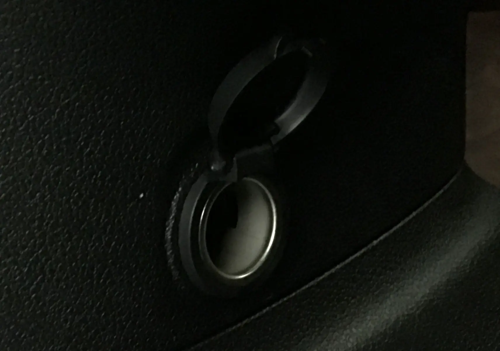 Prise allume-cigare noire ouverte dans l'habitacle du Peugeot Partner blanc, vue rapprochée du détail intérieur.