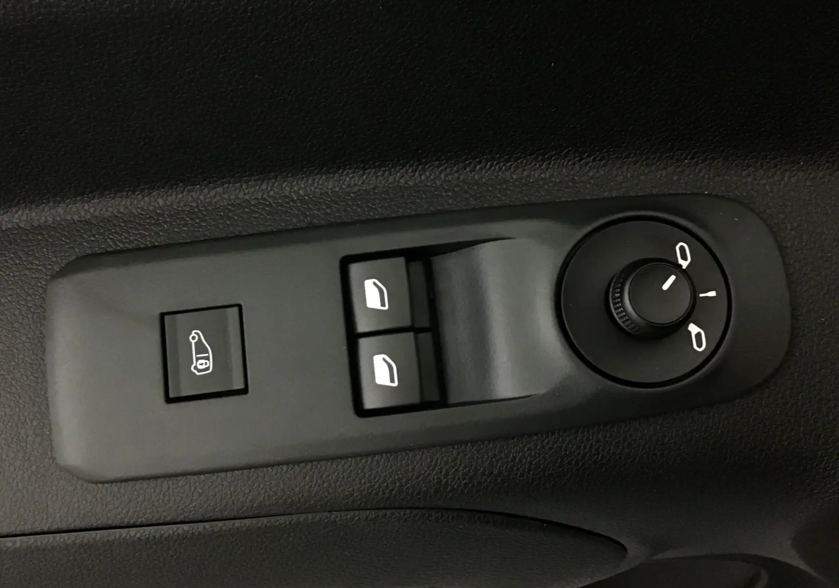 Gros plan sur les commandes de réglage des rétroviseurs et des vitres électriques côté conducteur du Peugeot Partner blanc.