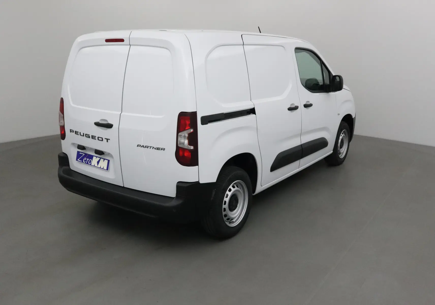 Vue 3/4 arrière droite d'un utilitaire blanc Peugeot Partner avec portes arrière battantes et jantes acier.