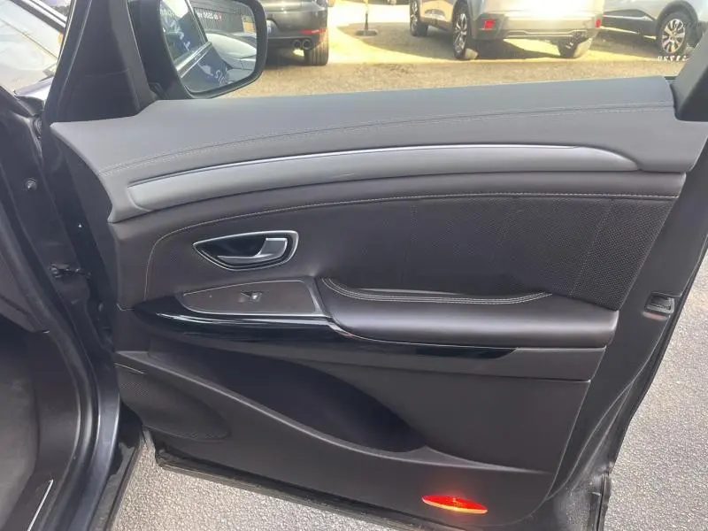 Gros plan sur la porte avant gauche du Renault Espace gris Cassiopée, montrant la garniture cuir et les commandes de fenêtre.