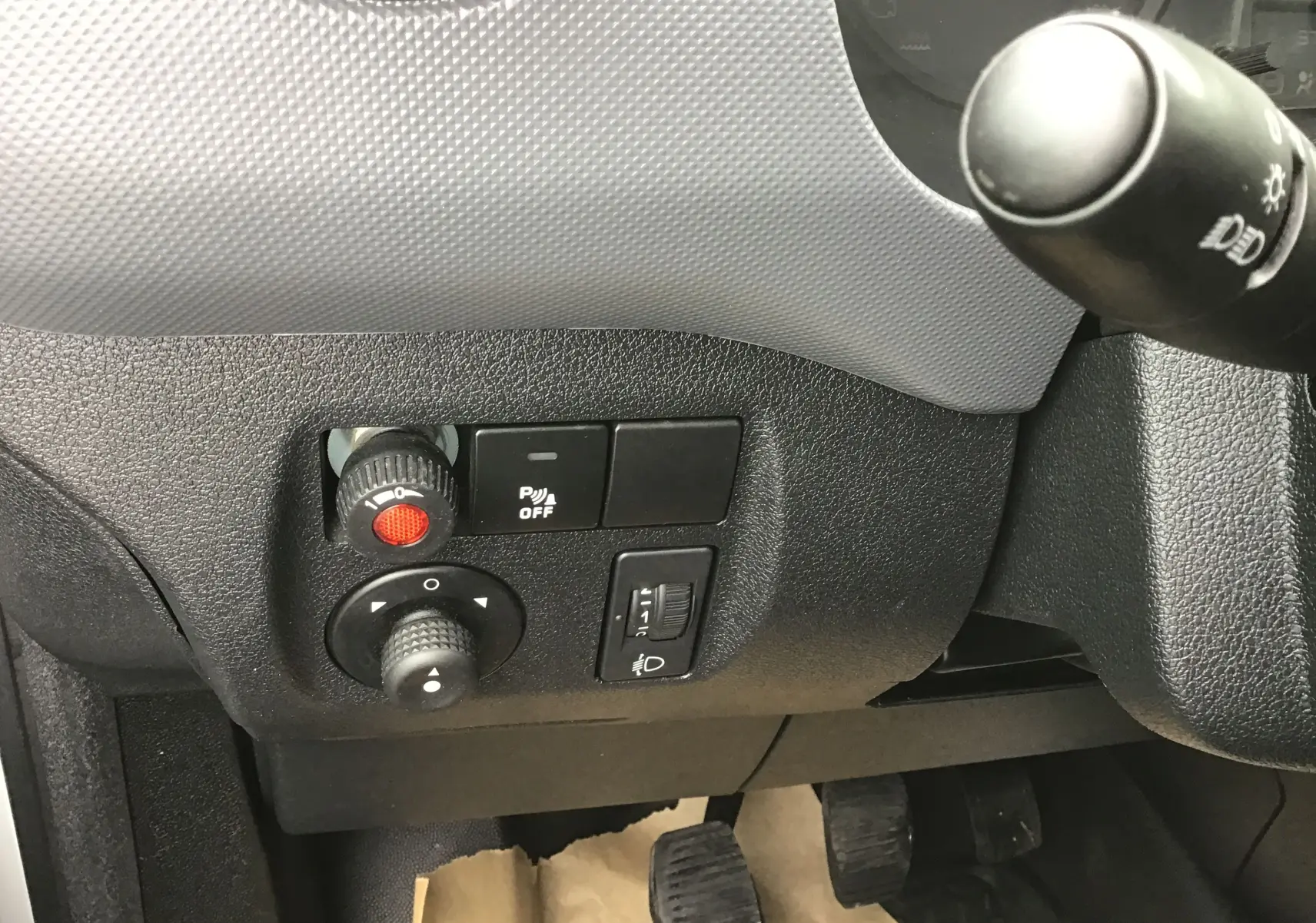 Gros plan sur les commandes côté gauche du tableau de bord du Citroën Berlingo blanc 2019, avec réglages et bouton de désactivation radar.
