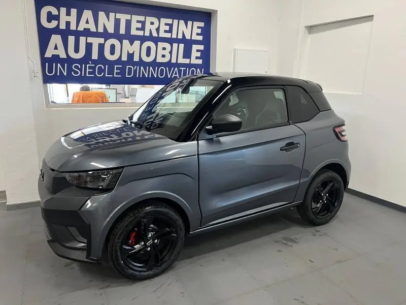 Vue 3/4 avant droite d'une LIGIER JS50 SPORT ELITE E5+ gris métallisé avec toit noir et jantes noires brillantes.