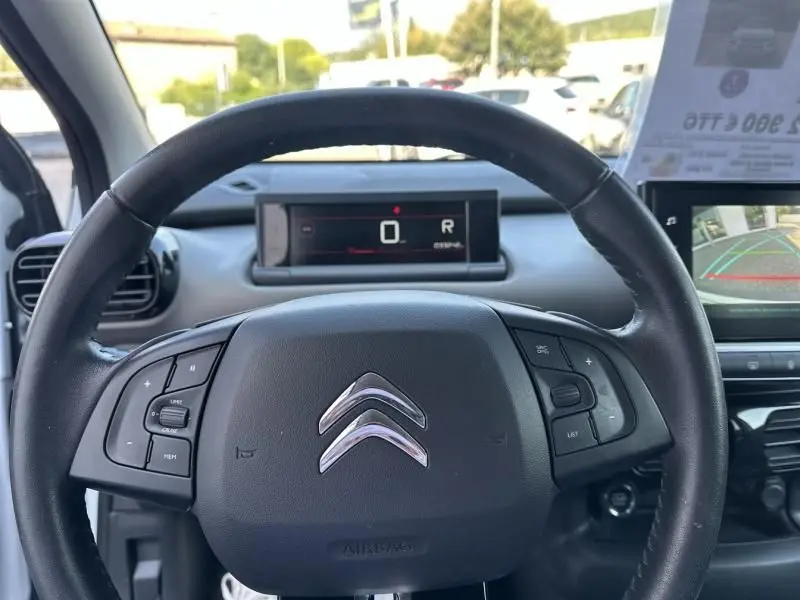 Vue centrée sur le volant noir d'une Citroën C4 Cactus blanche 2018, avec tableau de bord numérique et caméra de recul visible.