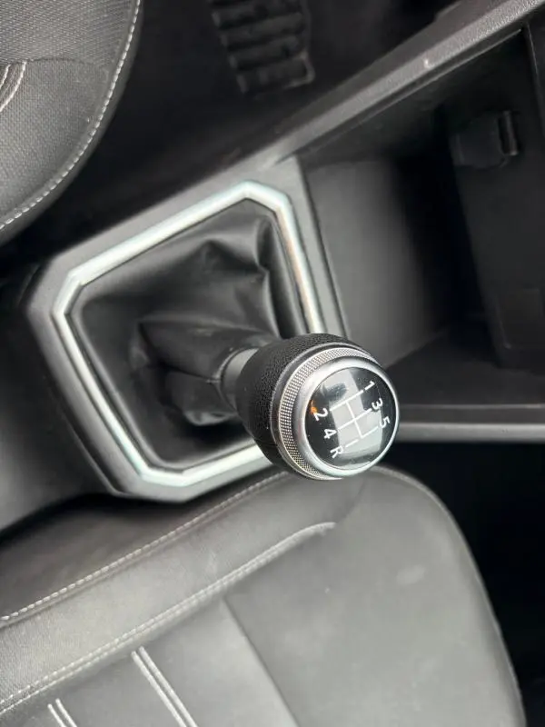Le levier de vitesse manuel noir de la Dacia Sandero SCe 65 Confort 2021 vu en gros plan depuis l'intérieur.