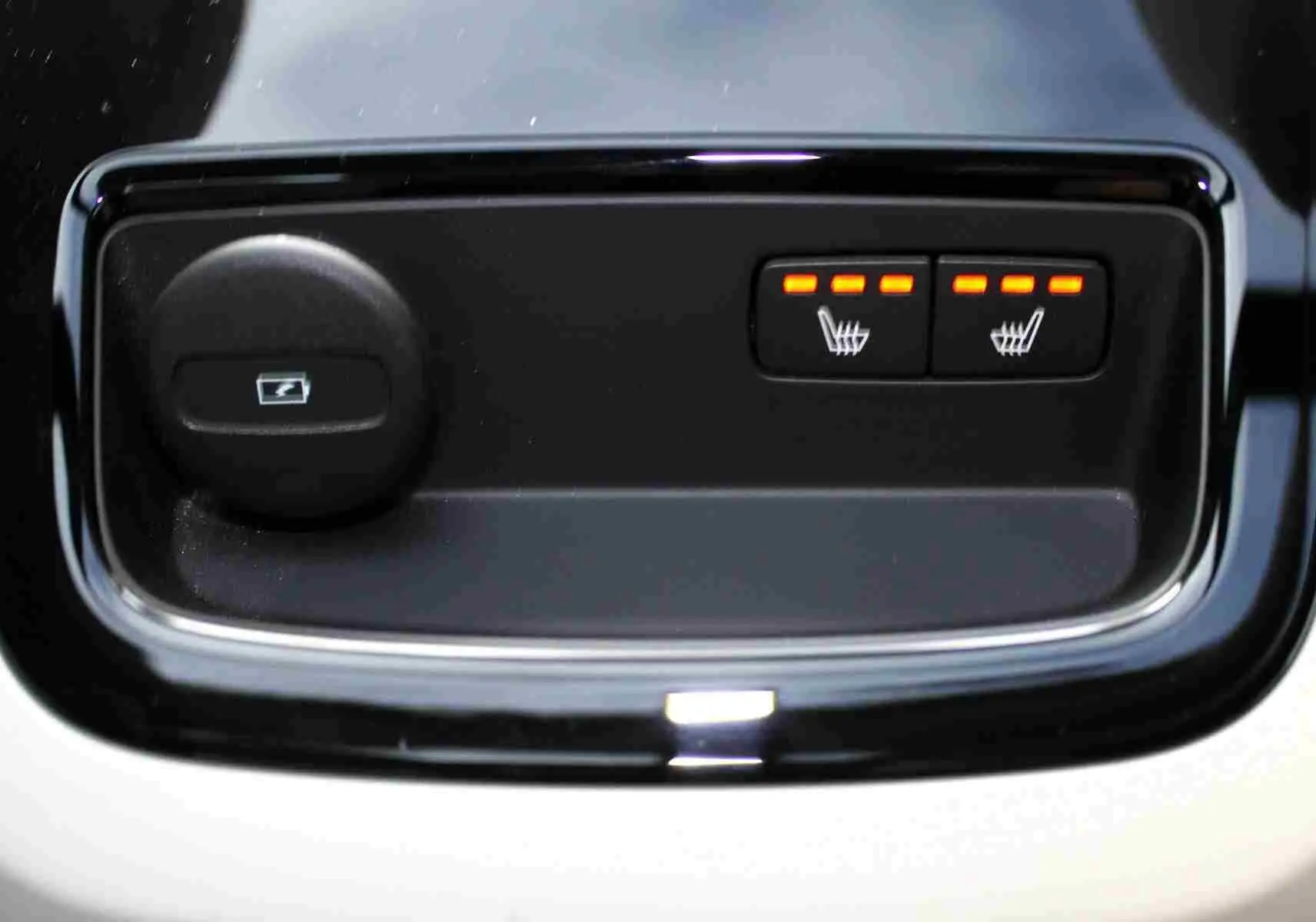 Gros plan sur les commandes de sièges chauffants et verrouillage de coffre du Volvo S60 gris métal 2024.