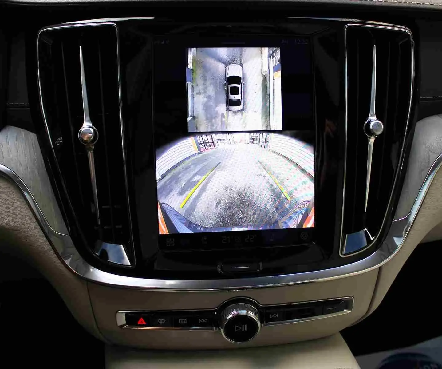 Écran central du Volvo S60 gris métal 2024 montrant la caméra de recul avec vue arrière et vue aérienne du véhicule.