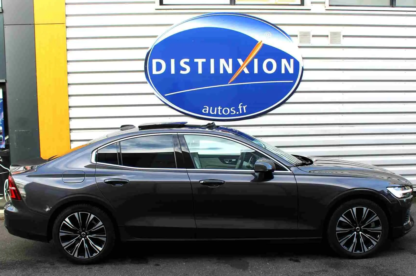 Profil côté gauche d'une Volvo S60 gris métal 2024 avec jantes alliage et toit ouvrant panoramique visible.