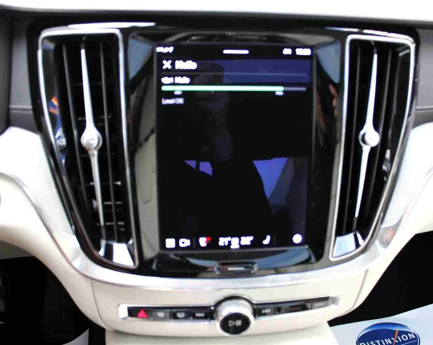 Écran tactile central avec commandes et aérateurs chromés dans l’habitacle clair du Volvo S60 T6 hybride 2024