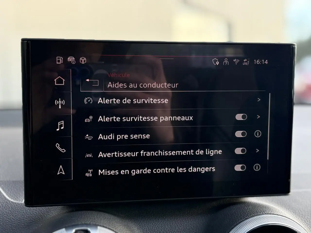 Écran central de l’Audi Q2 35 TDI 150 S-Tronic S-Line affichant les aides à la conduite, intérieur noir.