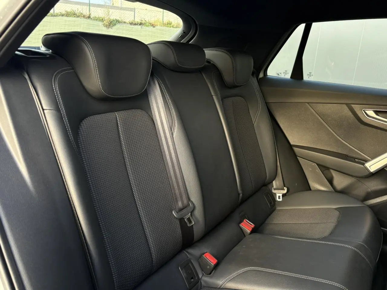 Vue intérieure côté droit des sièges arrière en cuir et tissu noirs de l'Audi Q2 35 TDI S-Line 2025.