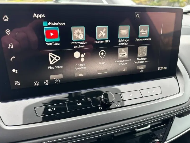 Écran tactile central du Nissan Qashqai Hybrid e-POWER 2025 montrant les applications connectées avec commandes audio en dessous.