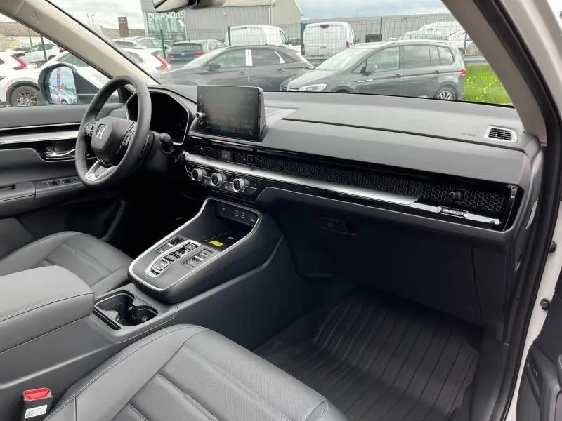 Vue intérieure côté conducteur du Honda CR-V 2024 avec tableau de bord noir, écran tactile central et sellerie cuir gris.