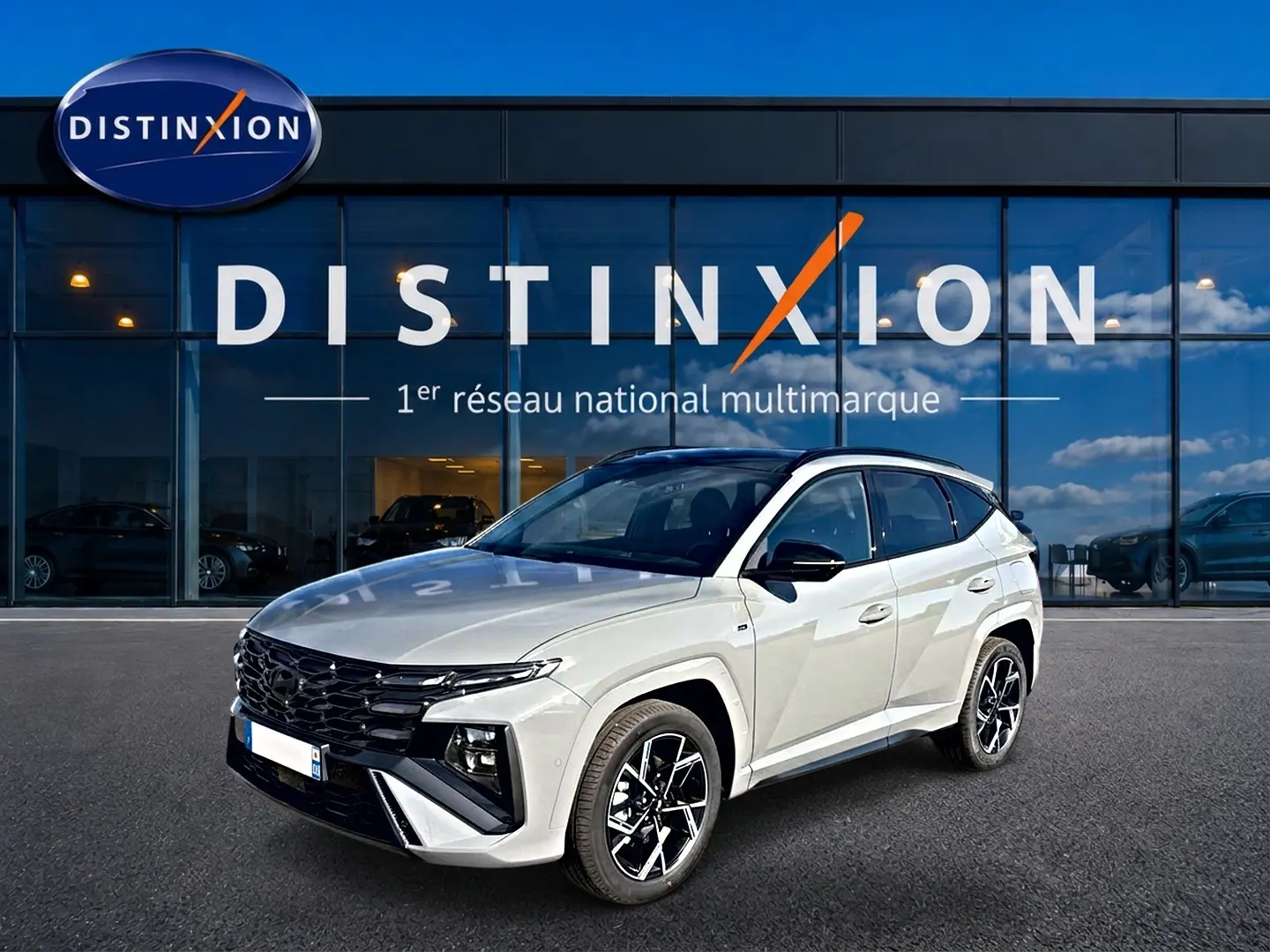 Hyundai Tucson 2026 gris shadow en 3/4 avant droit, avec calandre noire et jantes alu distinctives.