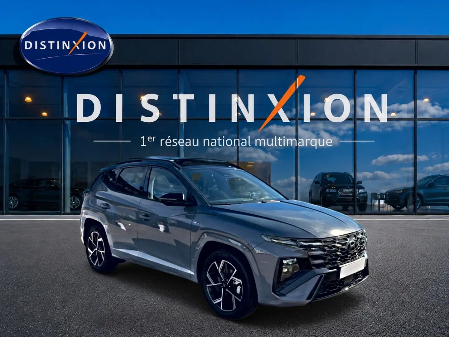Hyundai Tucson gris shadow en 3/4 avant droit, avec calandre noire et jantes alliage distinctives.