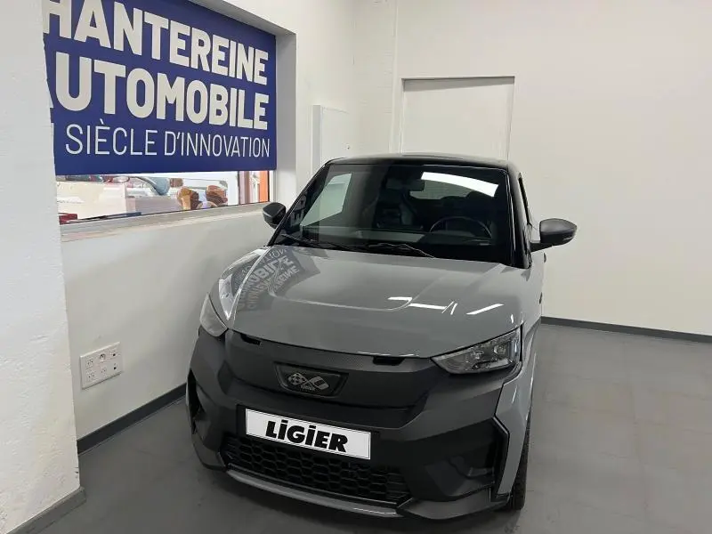 Vue 3/4 avant d'une Ligier JS50 Sport Ultimate E5+ gris métallisé avec calandre noire dans un showroom.