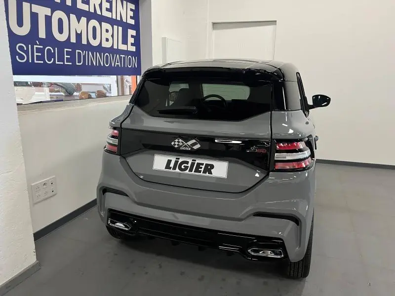 Vue arrière d'une LIGIER JS50 SPORT ULTIMATE E5+ gris avec toit noir et feux arrière LED en intérieur showroom.