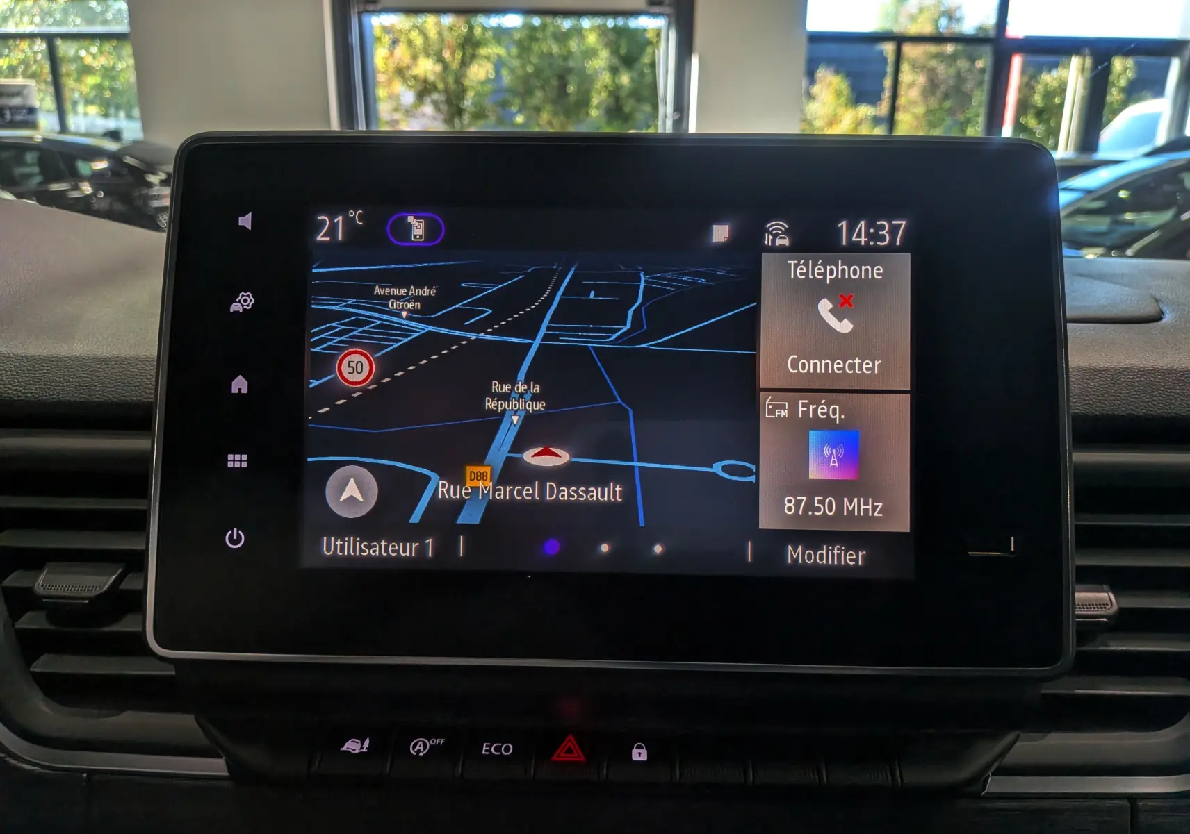 Écran tactile central du Renault Trafic Combi 2025 affichant la navigation et la radio, intérieur sombre.