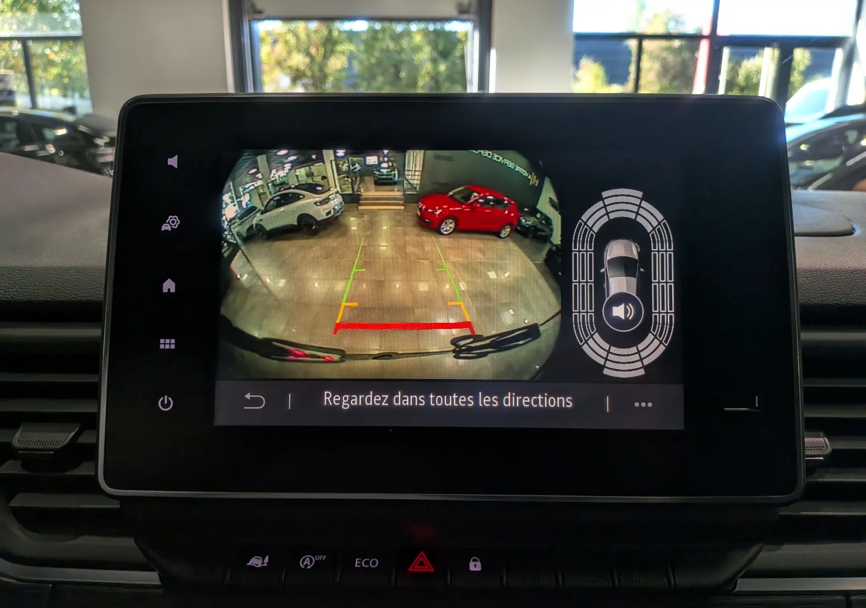 Écran de caméra de recul du Renault Trafic Combi gris comète montrant l’arrière en intérieur avec deux voitures visibles.