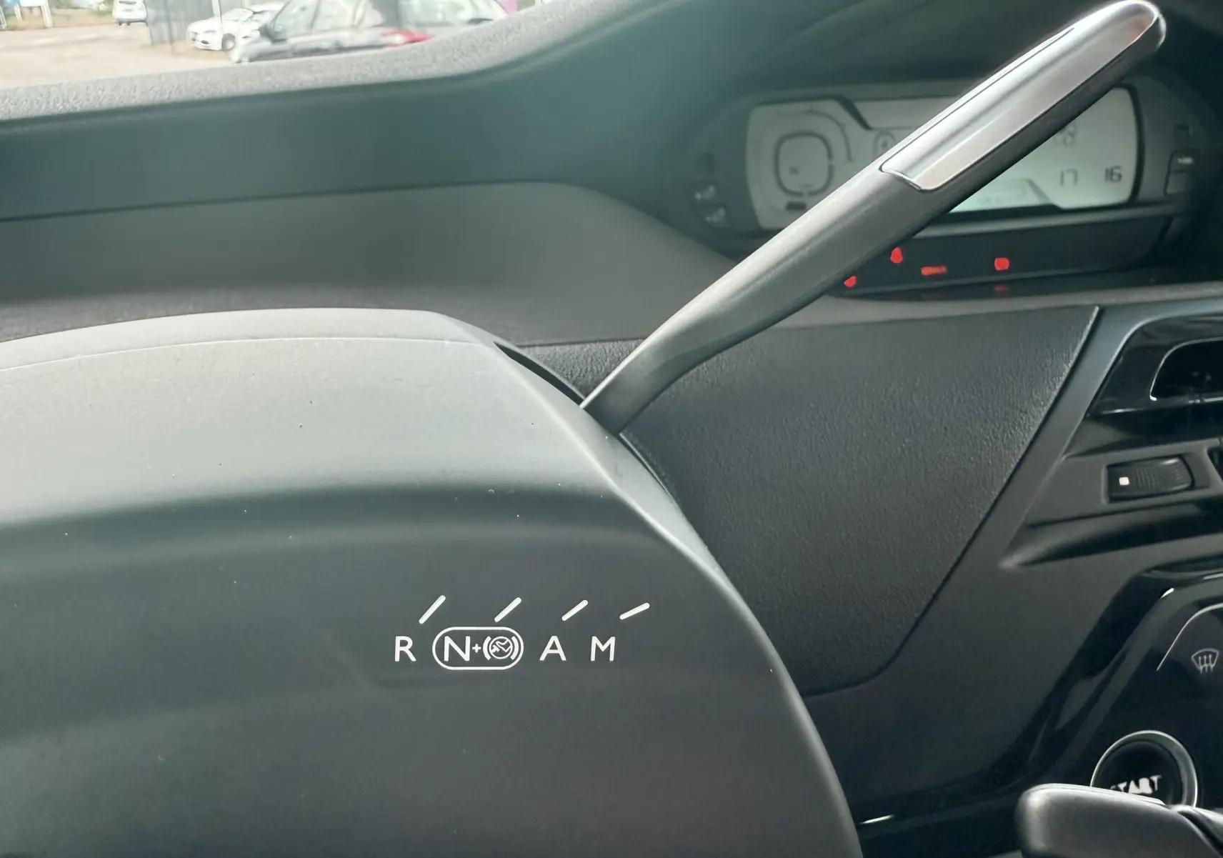 Gros plan sur la commande de boîte automatique du Citroën C4 Picasso blanc, avec indication des modes R, N, A, M.