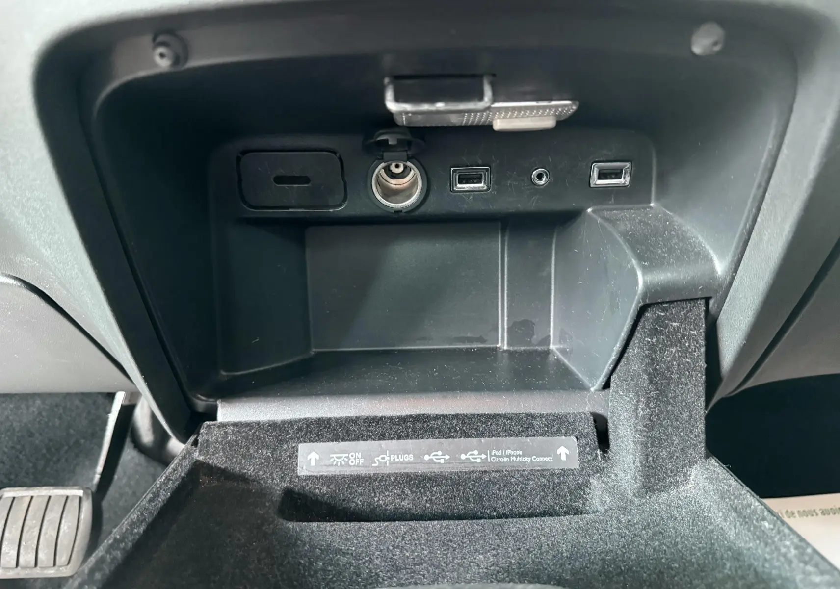 Vue rapprochée de la console centrale du Citroën C4 Picasso 2014, montrant les ports USB et prise allume-cigare.
