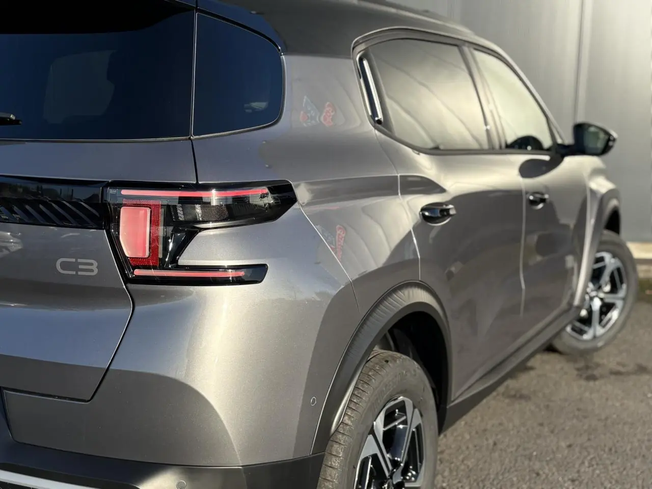 Vue 3/4 arrière droit du Citroën C3 Aircross gris Mercury avec toit noir et feux arrière LED distinctifs.