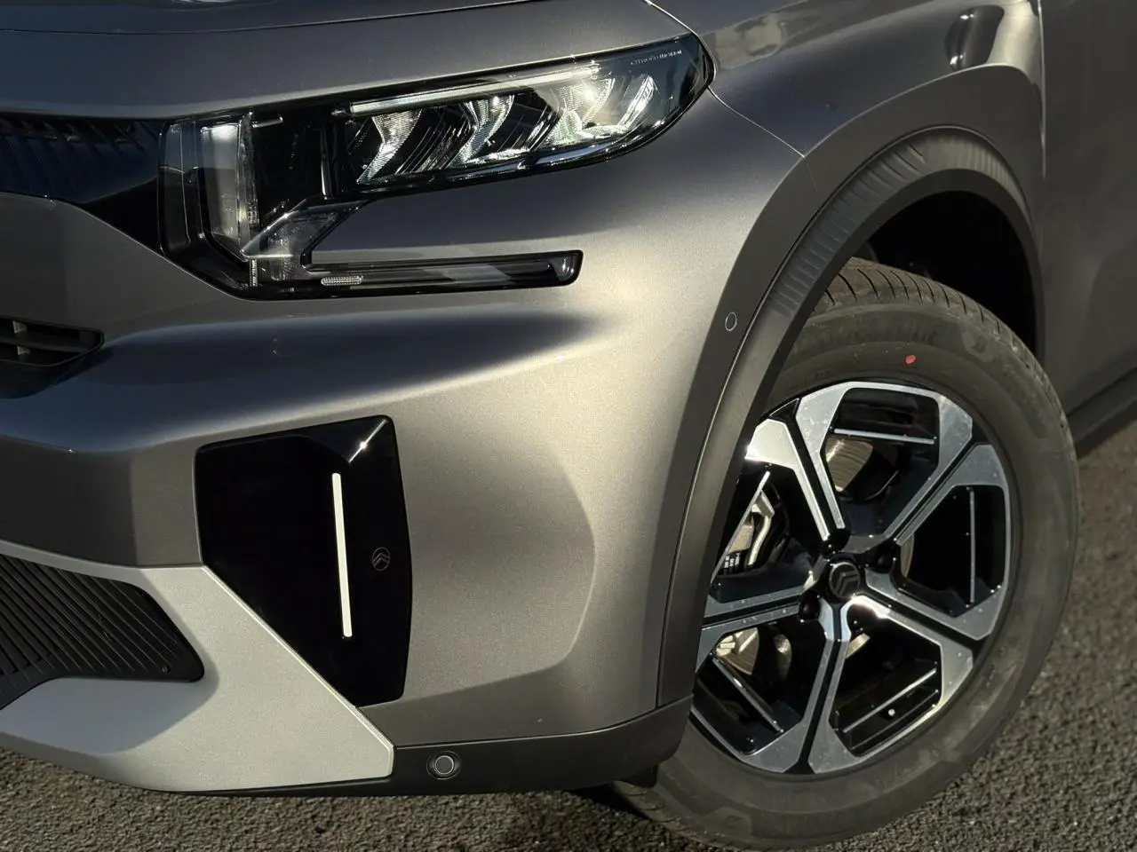 Gros plan sur l'avant droit gris Mercury du Citroën C3 Aircross 2025 avec phare LED et jante alliage noire et argent.