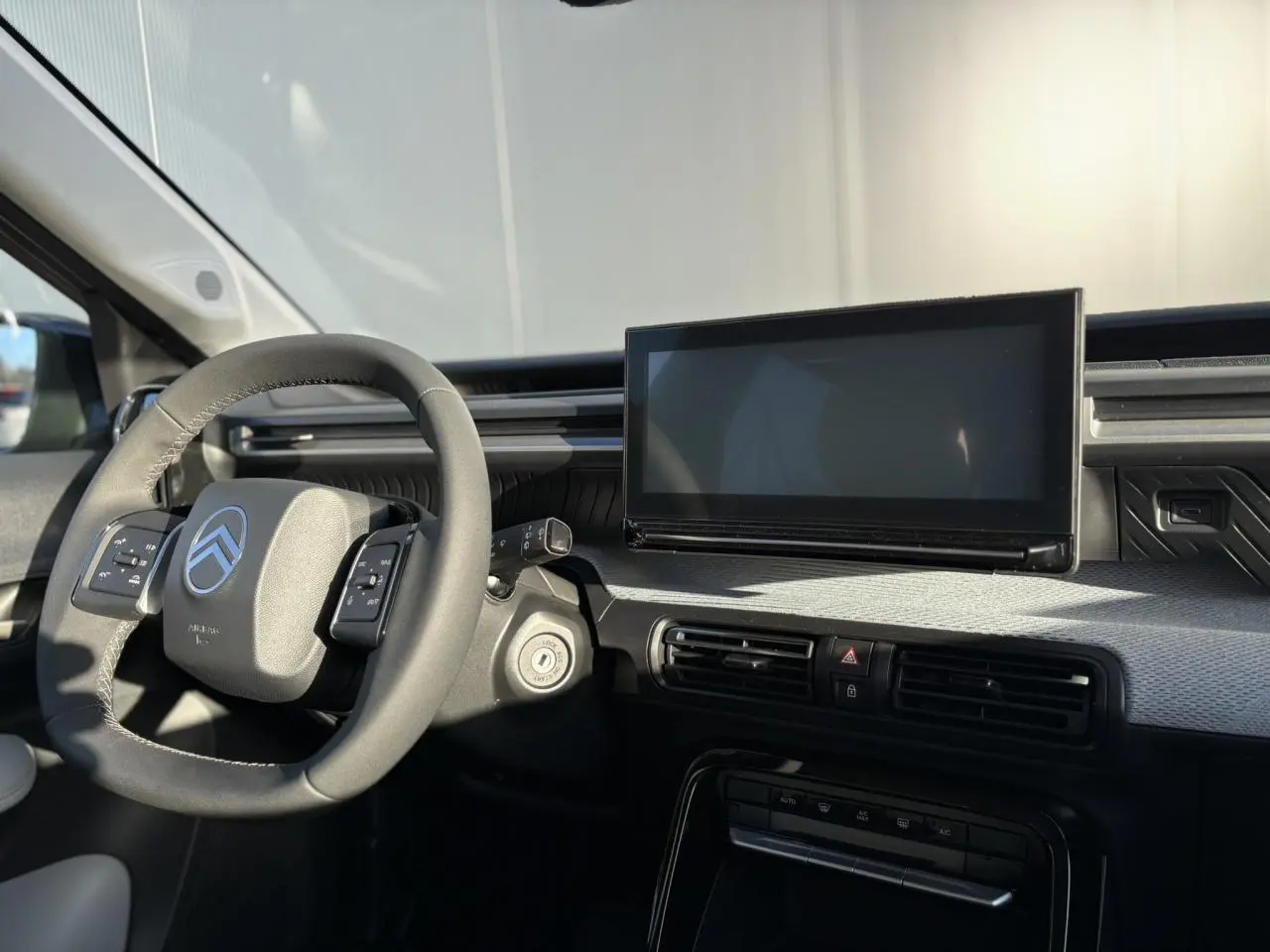 Intérieur avant du Citroën C3 Aircross 2025, tableau de bord gris Sidérite avec écran tactile et volant multifonctions noir.