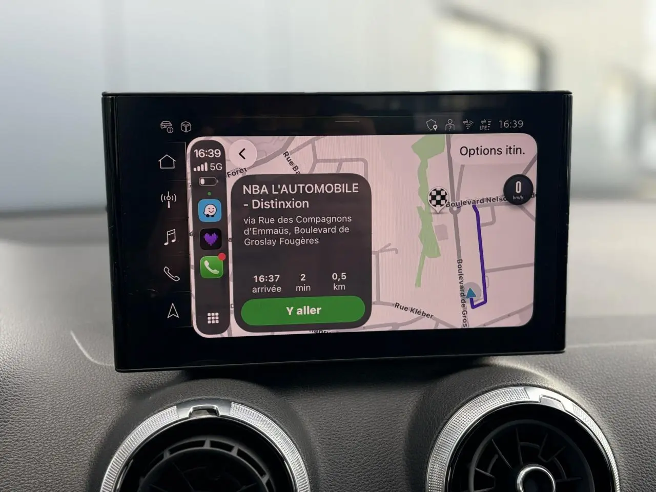 Écran central du système MMI navigation tactile affichant un itinéraire dans un Audi Q2 35 TDI rouge.