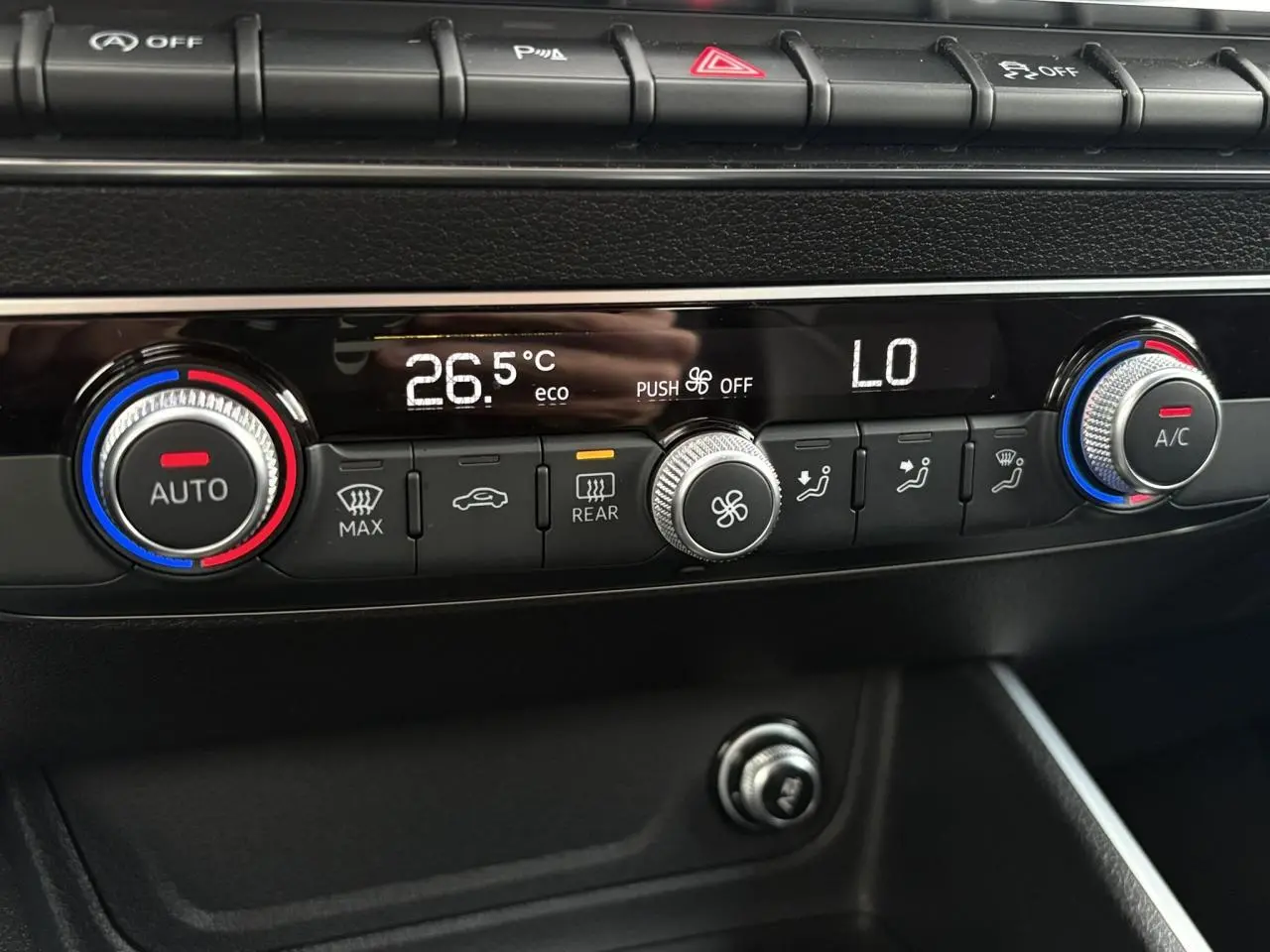 Détail de la console centrale de l’Audi Q2 35 TDI S-Line 2025, montrant la climatisation automatique avec réglages numériques.