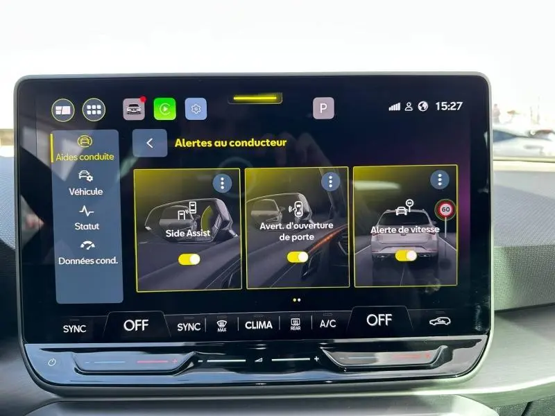 Écran tactile central du SEAT LEON ST 2025 montrant les alertes au conducteur avec interface moderne et commandes climatisation.