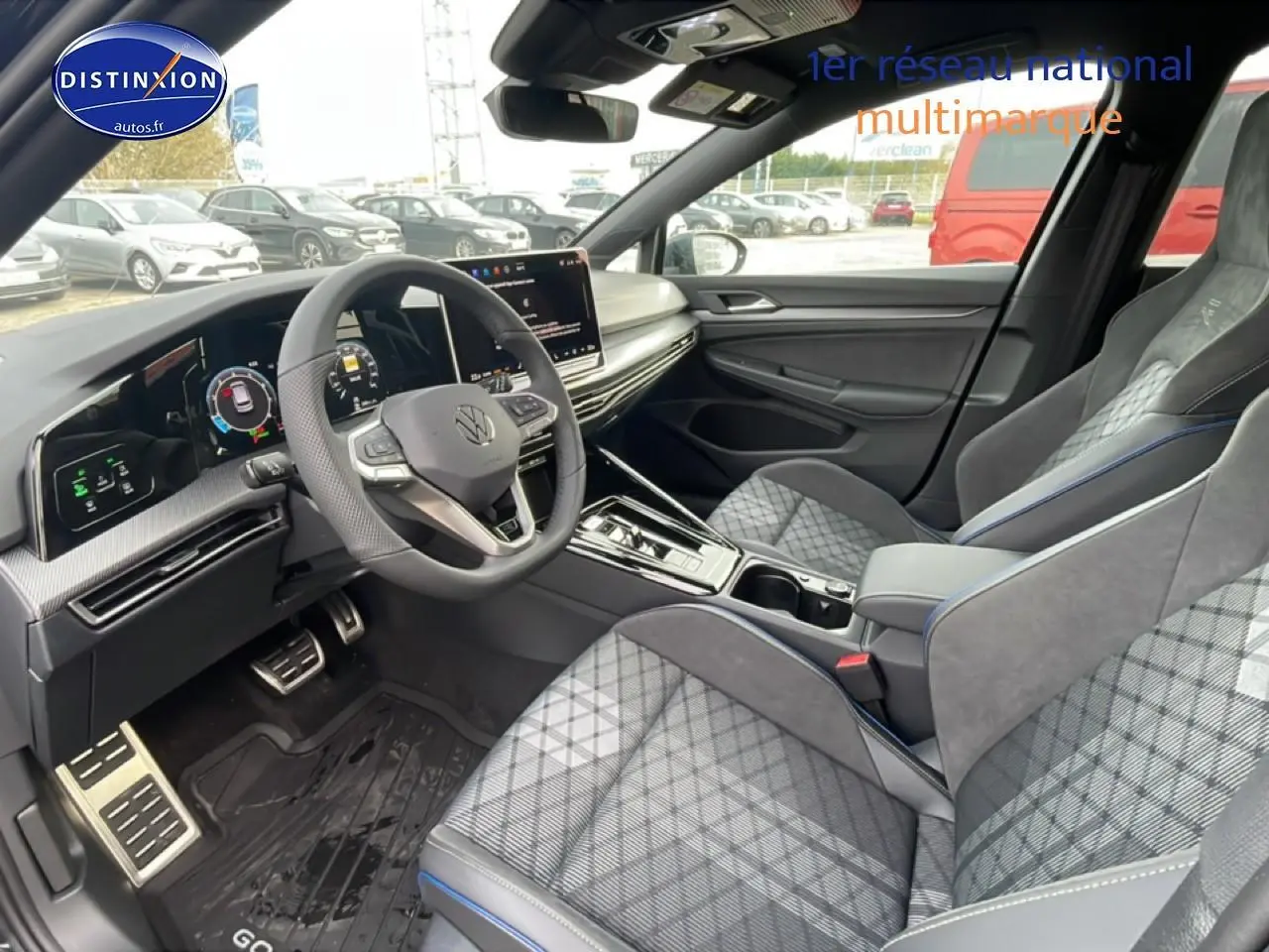 Vue intérieure côté conducteur de la Volkswagen Golf 1.5 eTSI R-Line 2026 avec sièges sport gris à motif tartan et volant cuir multifonction.