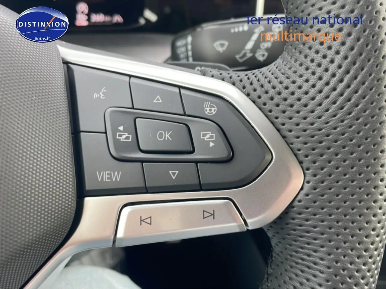 Gros plan sur les commandes multifonctions en cuir perforé du volant noir de la Volkswagen Golf 1.5 etsi evo2 150 R-Line 2026.