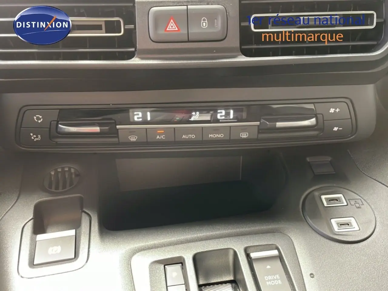 Vue rapprochée du tableau de bord du Citroën Berlingo gris, montrant la climatisation digitale et les commandes centrales.