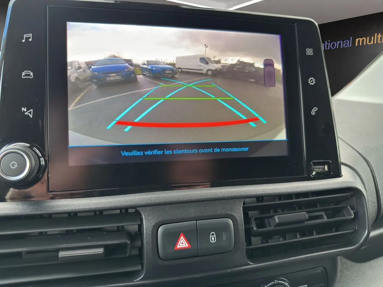 Écran central du Peugeot Partner 2022 montrant la caméra de recul avec lignes de guidage colorées.