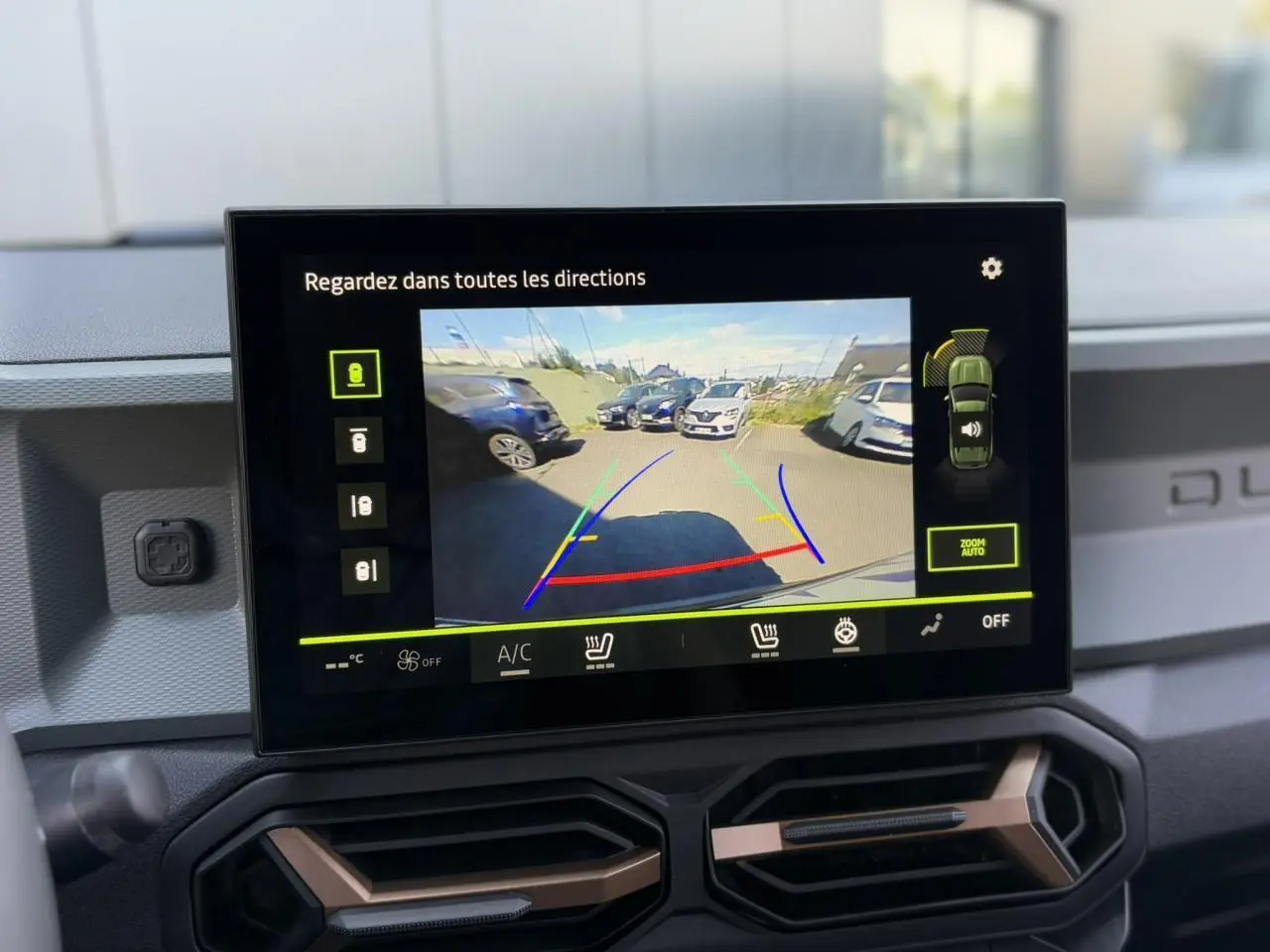 Écran tactile intérieur du Dacia Duster 2025 montrant la caméra 360° en marche avec vue arrière du parking.