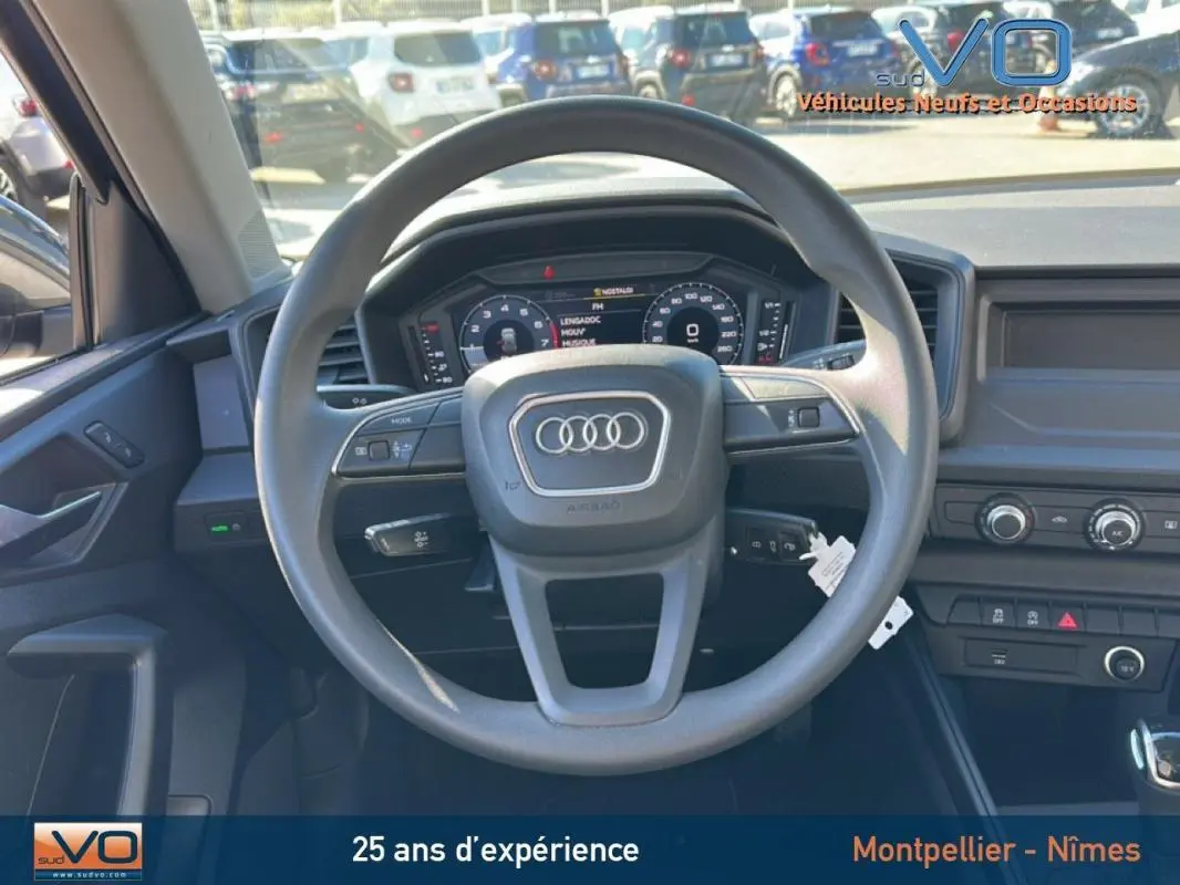 Vue intérieure centrée sur le volant Audi A1 Sportback 30 TFSI 2020 avec tableau de bord numérique et commandes intégrées.