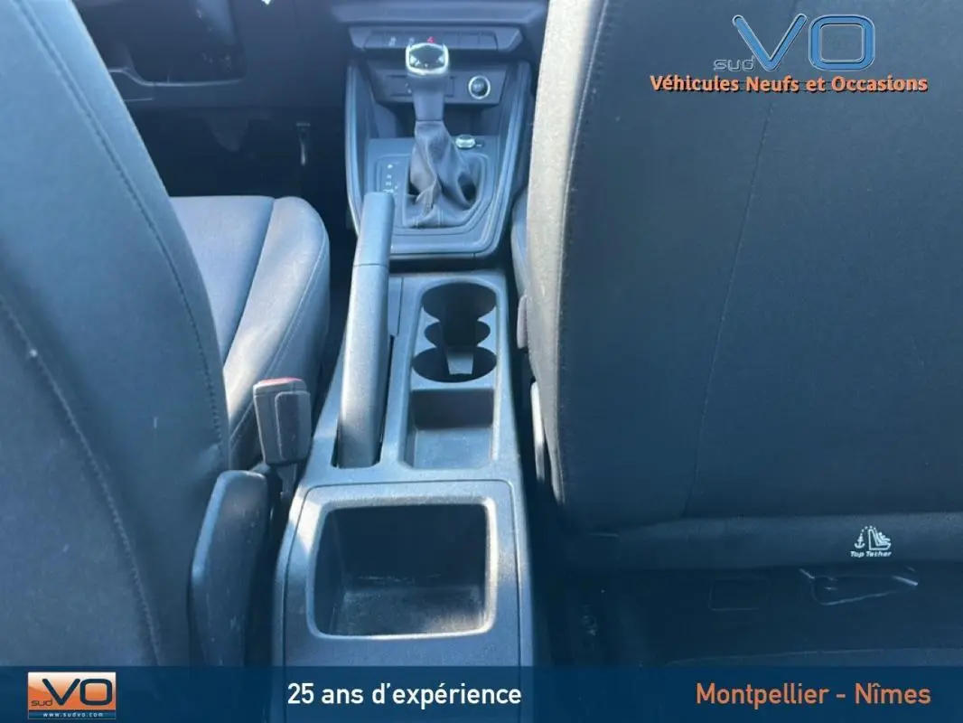 Vue intérieure centrée sur la console centrale et levier de vitesse d'une Audi A1 Sportback gris foncé de 2020.