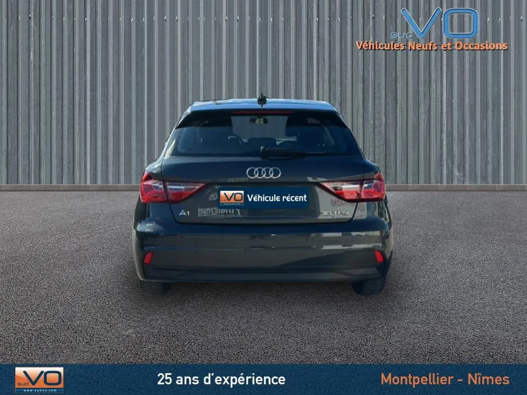 Vue arrière d'une Audi A1 Sportback gris foncé 2020 avec feux arrière allumés et radar de stationnement visible.