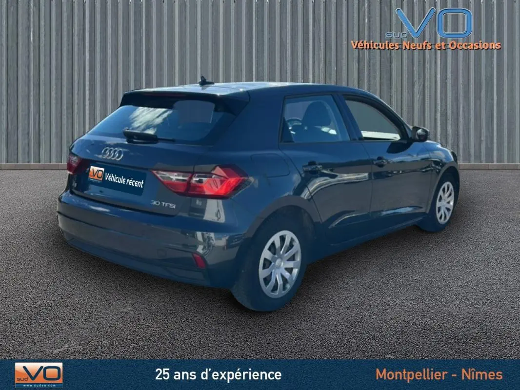 Audi A1 Sportback gris foncé vue 3/4 arrière droit, avec feux arrière et jantes visibles sur fond neutre.